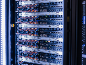 Instalación de rack de comunicaciones ordenado con cableado estructurado Categoría 6A y fibra óptica en oficina corporativa de Madrid.
