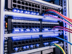 Instalación de rack de comunicaciones ordenado con cableado estructurado Categoría 6A y fibra óptica en oficina corporativa de Madrid.